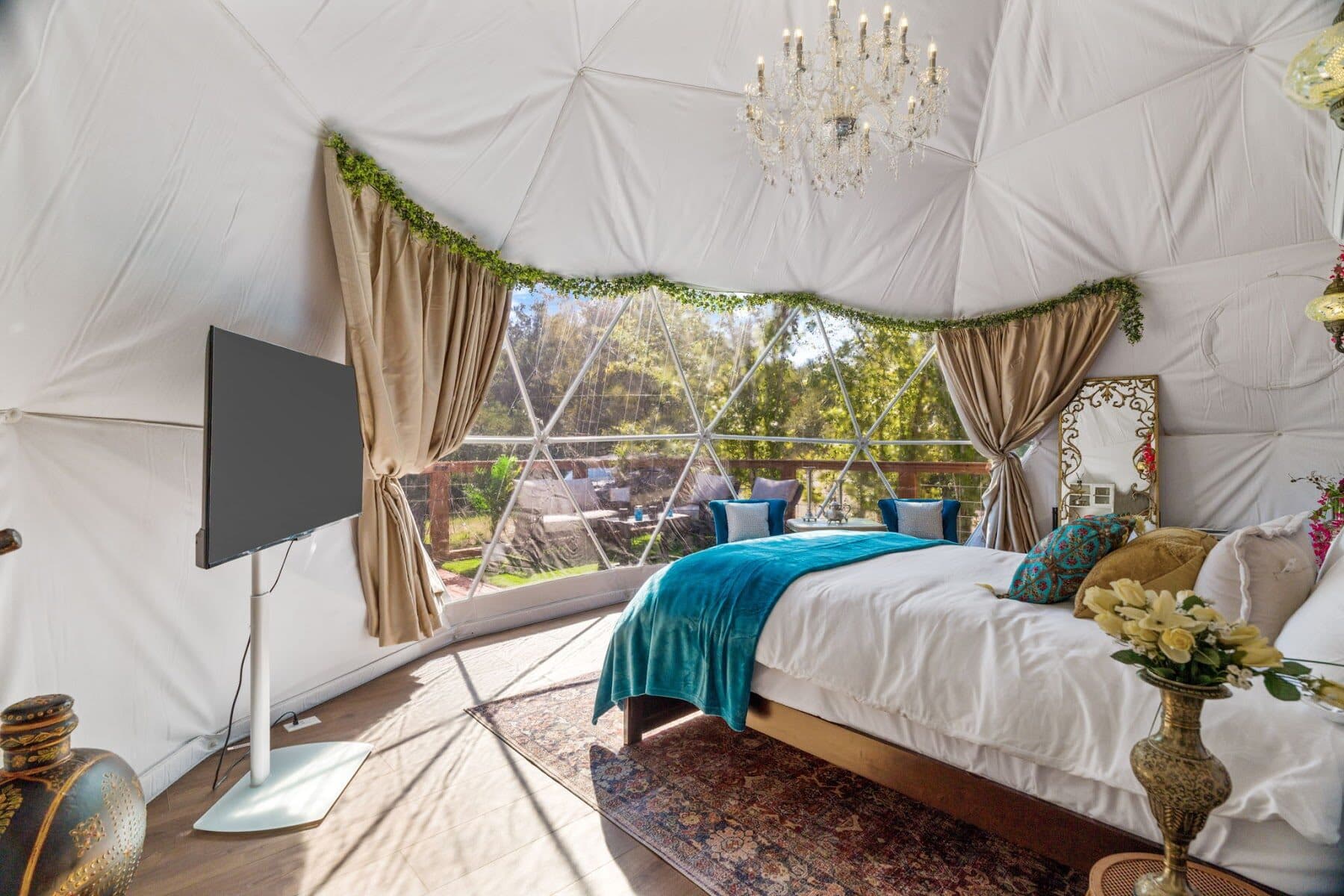 Desert Rose geodome bedroom with chandelier and forest views at Zenfulcove near Austin, Texas