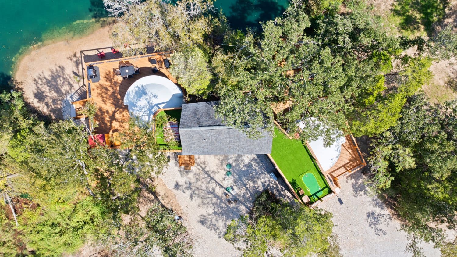 Aerial view of the Fairy House geodomes beside the oak-lined pond at Zenfulcove in Elgin, Texas, as featured in Texas Highways