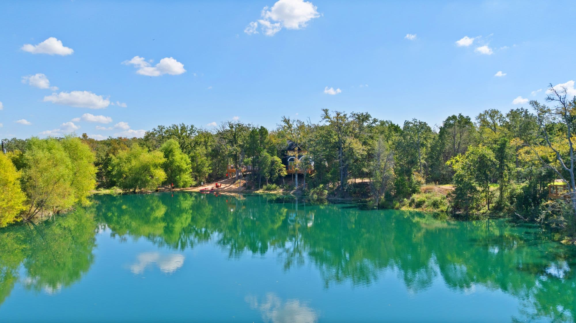 Turquoise lagoon reflecting the oaks at Zenfulcove, a nature stay near Austin